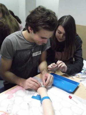 Young Persons Advisory Group members having a go at doing a blood test on a fake arm